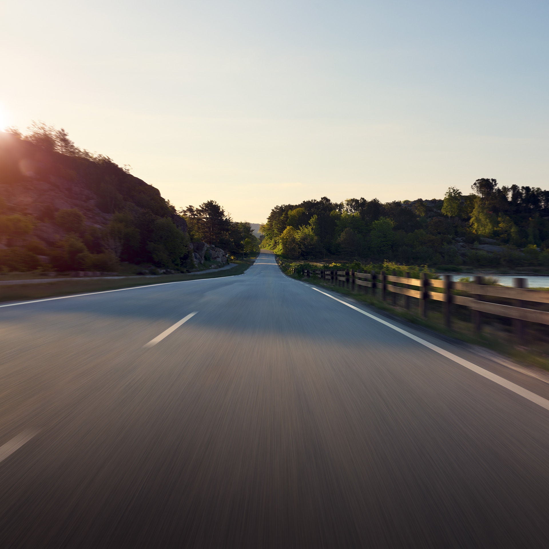 A long, perfectly straight, empty country road in the sunshine.