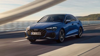 Die S3 Limousine von schräg vorne überquert eine Brücke, im Hintergrund ein Gewässer.