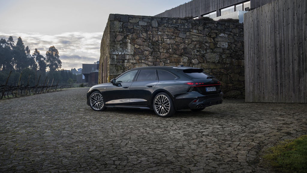 The all-new A6 Avant parked outside a home.