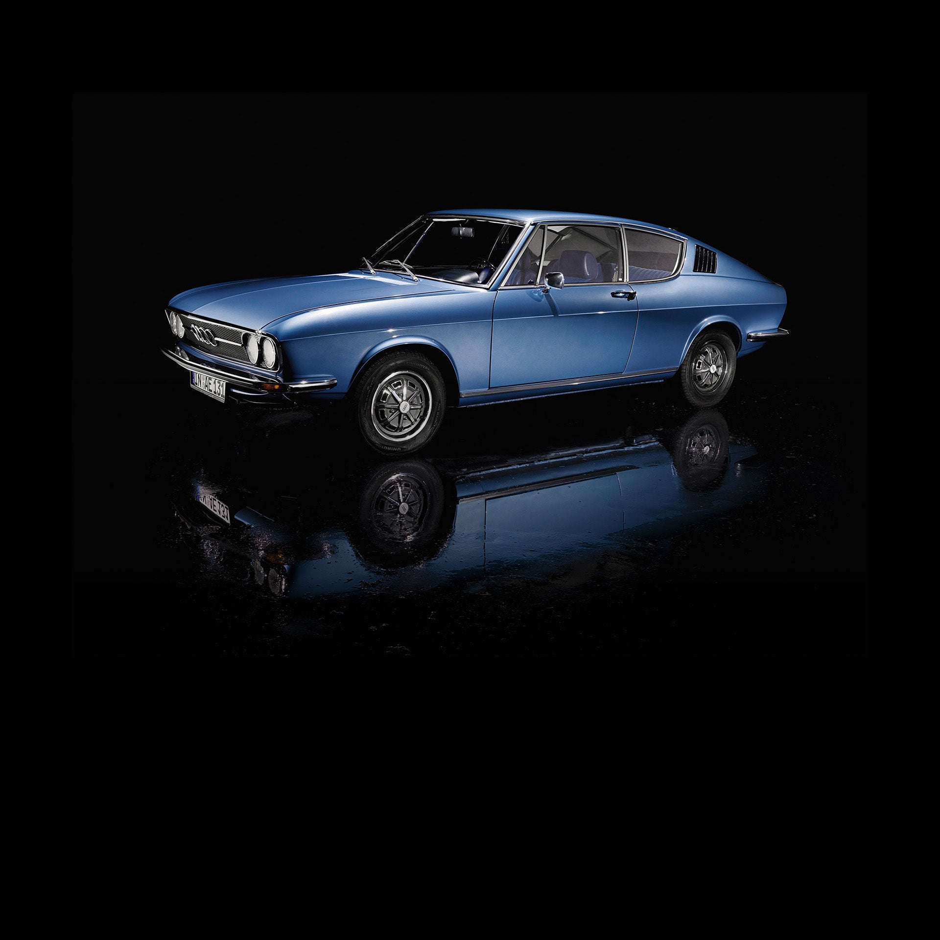 Blauer historischer Audi in einem schwarzen Raum