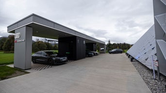 Audi Charging Hub Kiefersfelden bei Tag inmitten einer Grünfläche