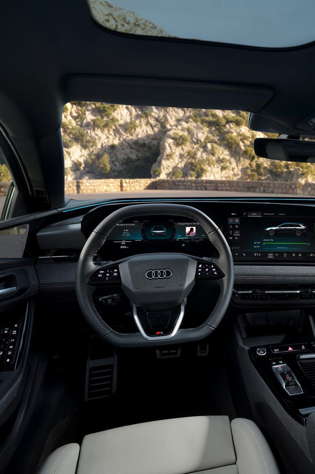 The interior of an Audi vehicle featuring a sleek dashboard with multiple digital displays, a stylish steering wheel, and modern controls.