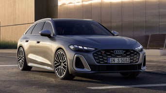Der S5 Avant steht auf einem Parkplatz vor einem modernen Gebäude, schräg von vorn fotografiert.