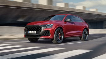 Roter Audi RS Q8 SUV performance fährt auf städtischer Straße.