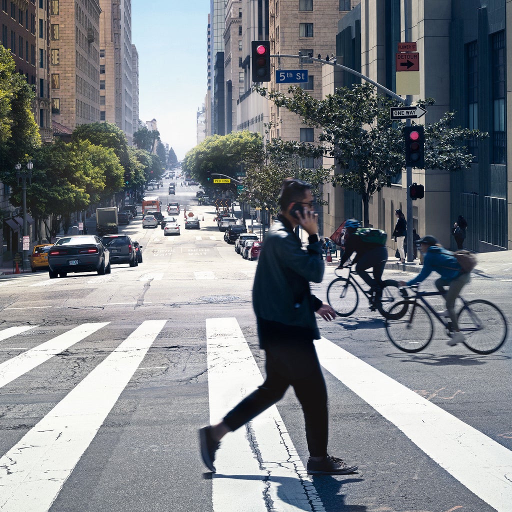En bild på ett övergångsställe som visar cyklister, bilister och fotgångare.