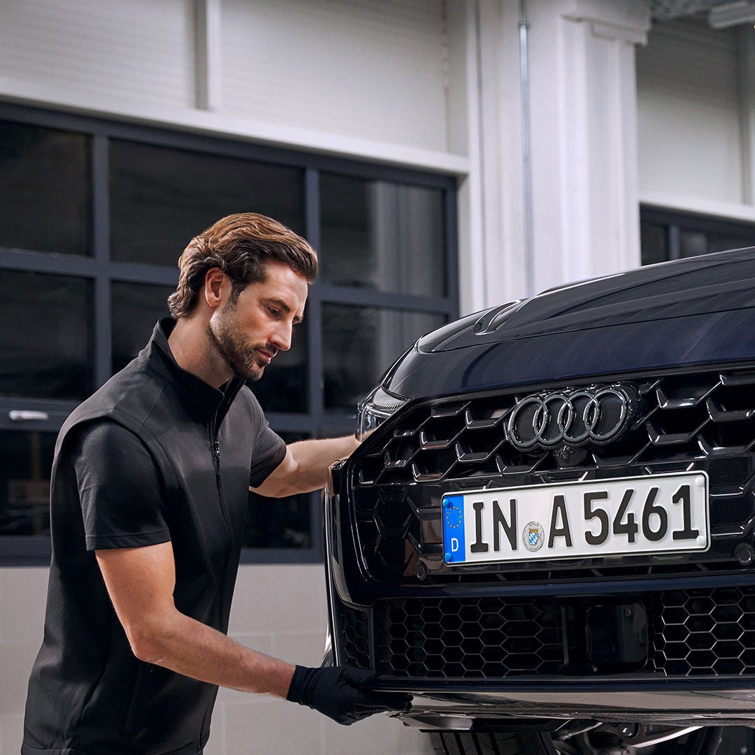 Hombre revisando refacciones originales de un Audi