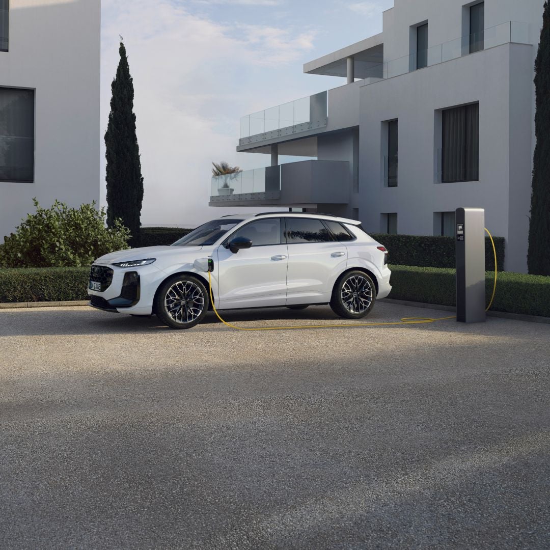 A parked grey Audi electric vehicle with focus on the front left of the vehicle visible to us