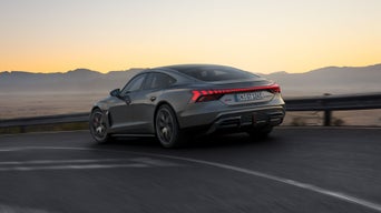 Schräge Heckansicht des S e-tron GT, welcher um eine Kurve entlang der Küste fährt.
