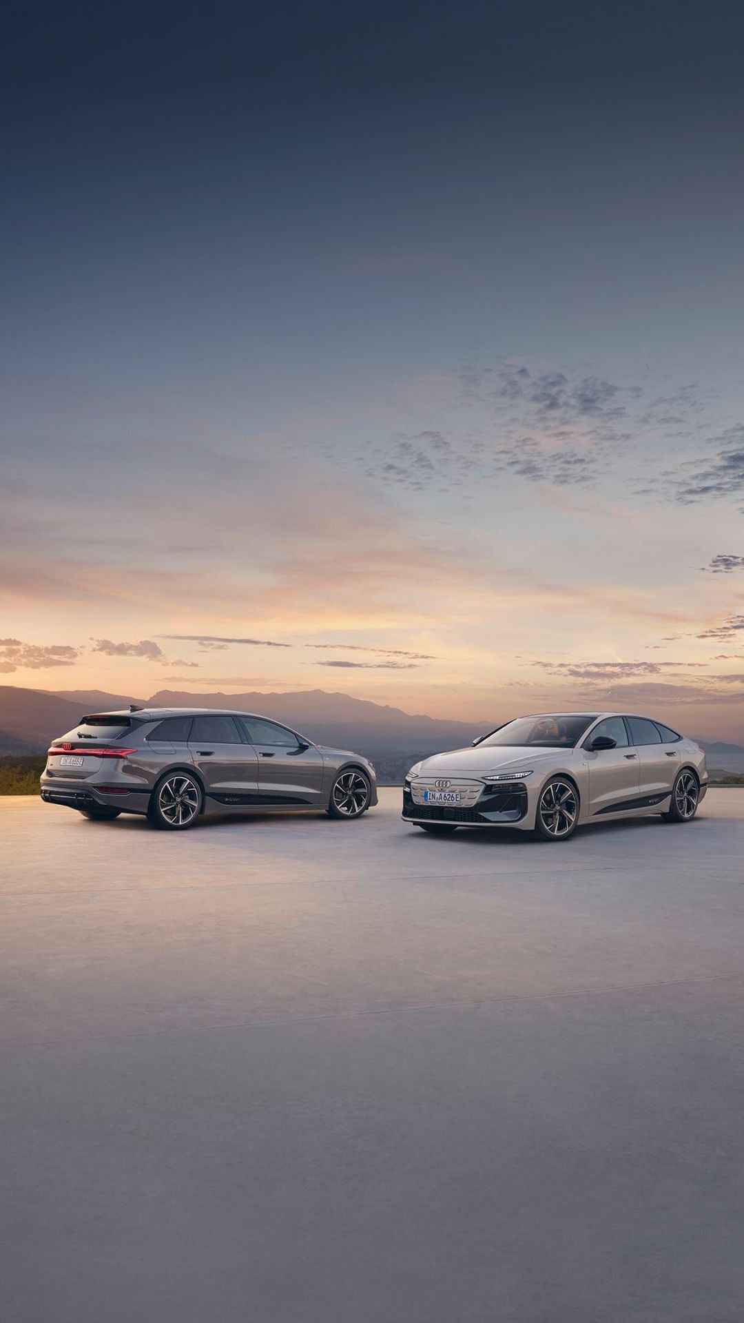 A Silver Audi parked in an outdoor lot with modern buildings in the background.