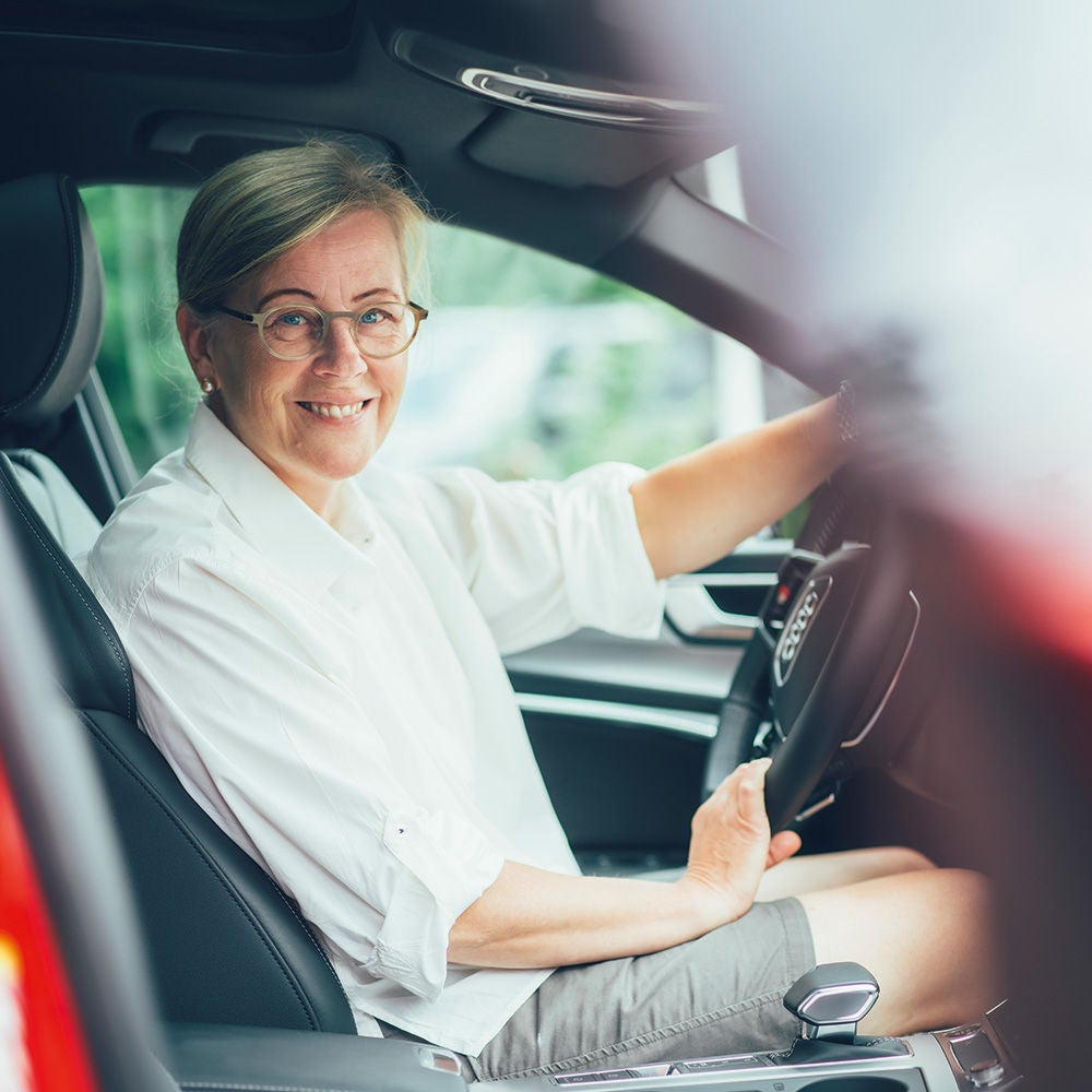 Ulrika tittar fram från förarplatsen i sin Audi A6