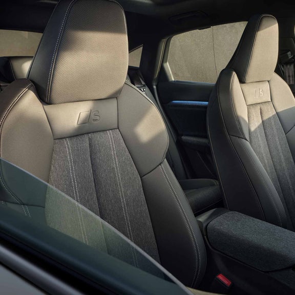 The front two seats of the Q6 Sportback e-tron from the perspective of the half-open passenger window.