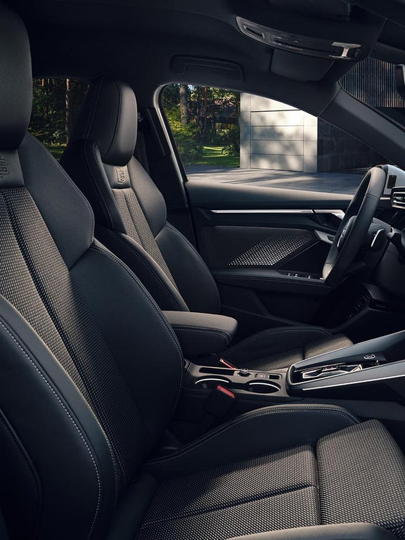 Vorderansicht des Audi-Innenraums mit Sportsitzen in Schwarz mit geprägtem S-Logo.