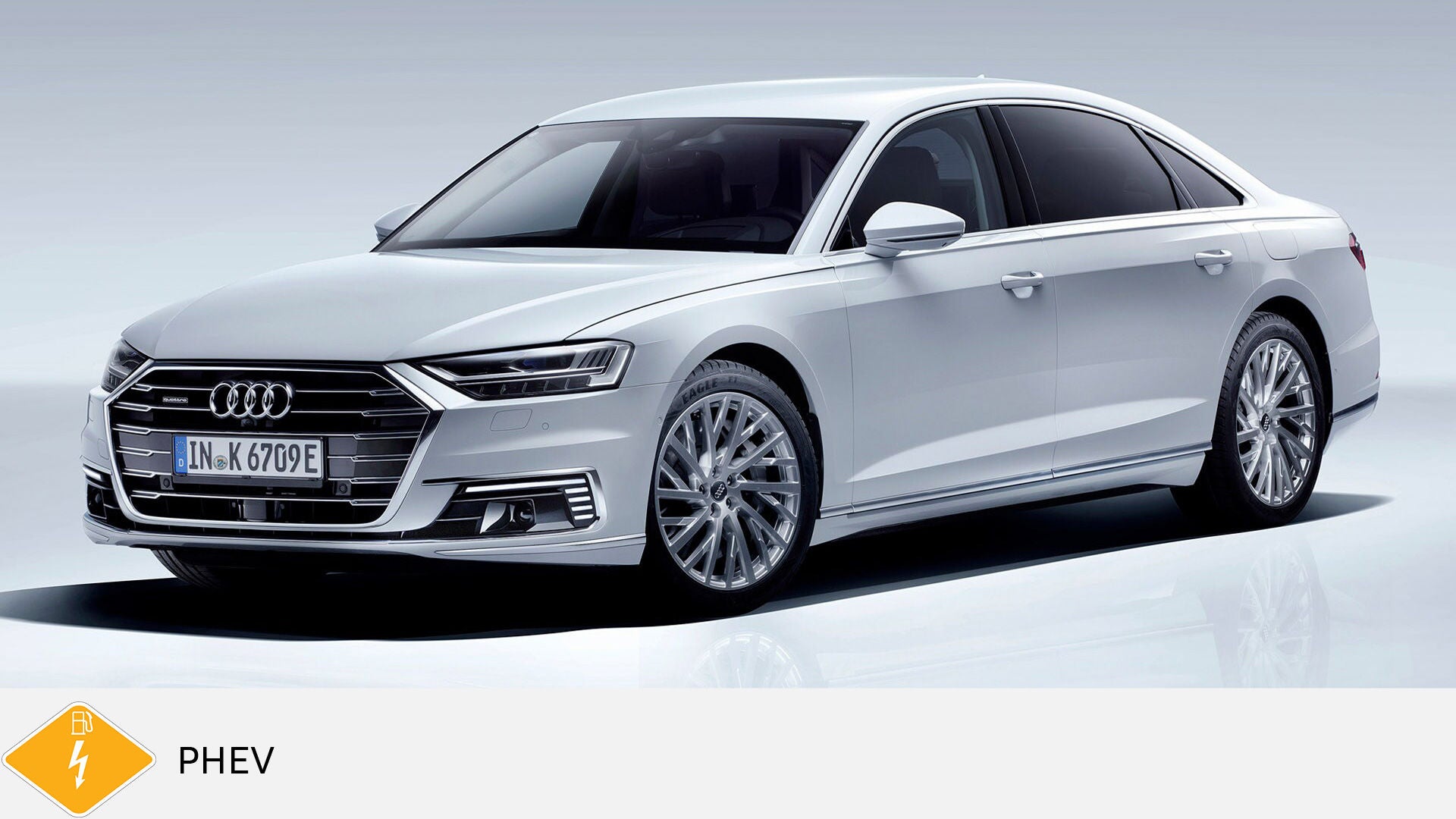 White Audi A8 TFSI e standing in a studio with a light background. Yellow PHEV symbol with petrol pump below.