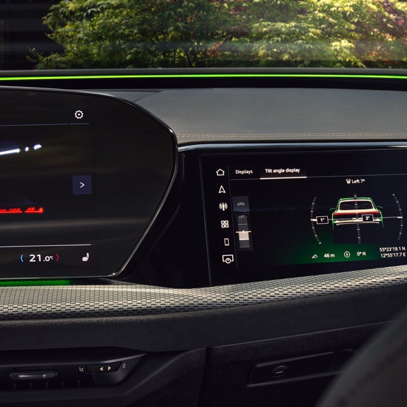 Car's interior view of a digital display showing vehicle tilt angle and GPS coordinates with ambient lighting.