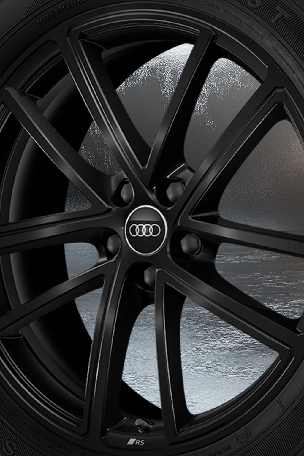 La couleur noir métallique de la jante Audi Sport de 20 pouces à cinq doubles branches oscille entre lumière et ombre.  