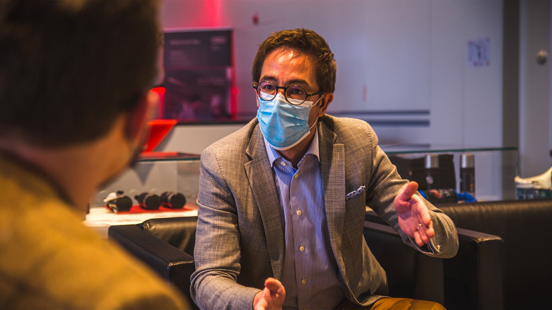 Un homme avec un masque de visage assis sur un canapé