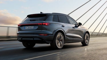 De SQ6 e-tron is vanuit een schuin achterperspectief te zien terwijl hij over een brug rijdt.