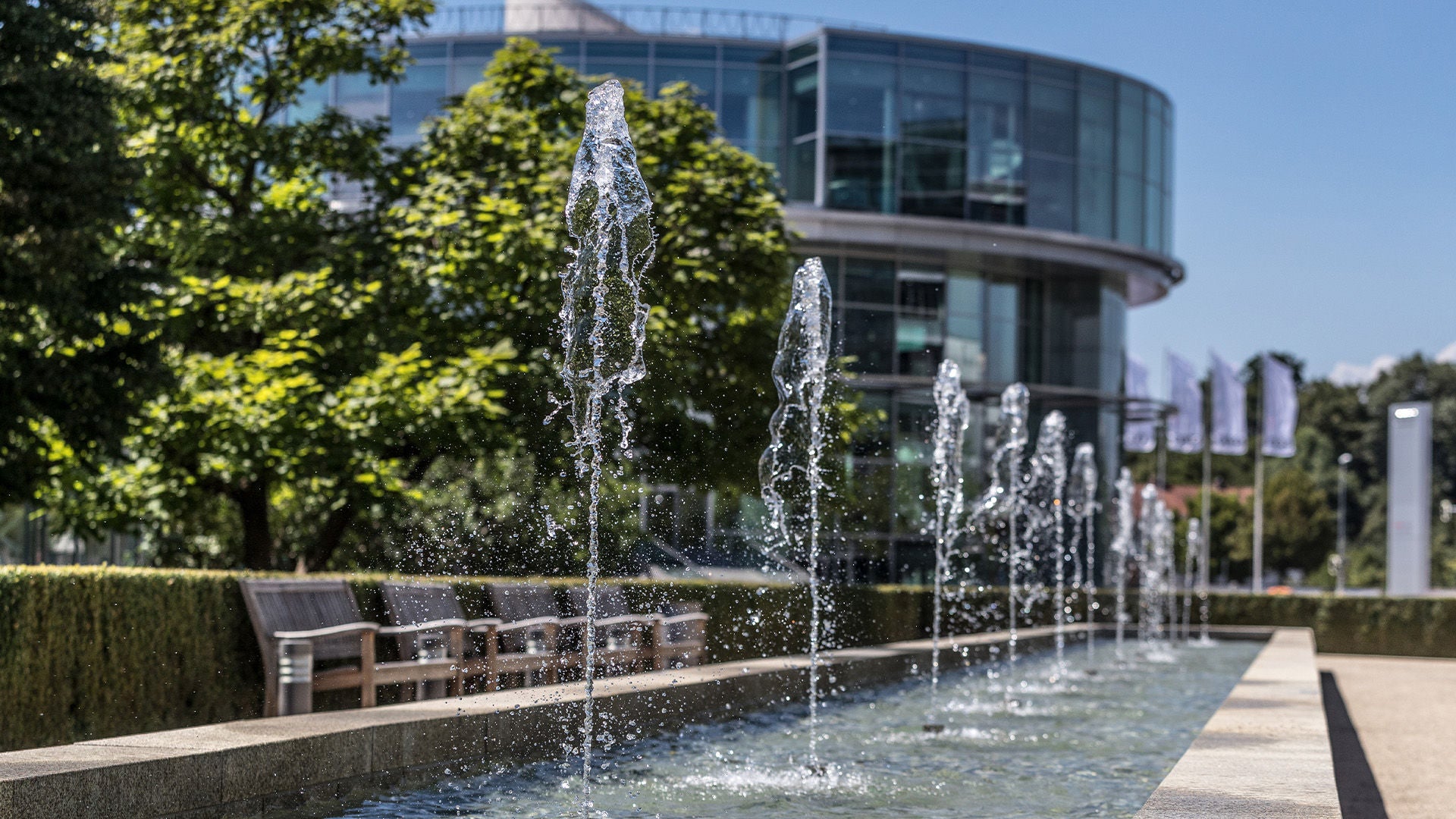 Gebäude des Audi Forum Ingolstadt, davor kleine Wasserfontänen.
