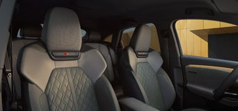 Zwei vordere Sportsitze mit Rautensteppung und grünen Ziernähten im Innenraum eines Audi SQ6 Sportback e-tron.