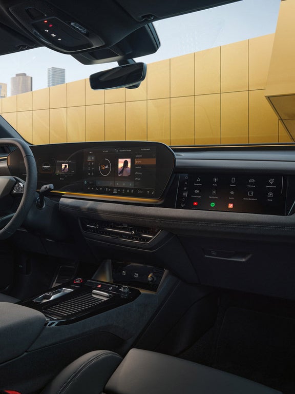 Digitales Cockpit mit gelber Zierleiste und großem Infotainmentbildschirm im Audi-Innenraum.