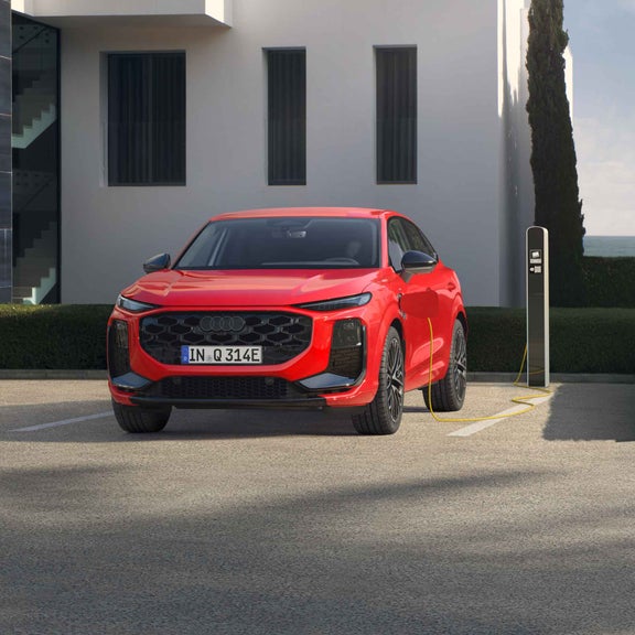 Punane Audi Q3 Sportback e-hybrid eest külgvaates, parklas, kus on laadimisjaam.
