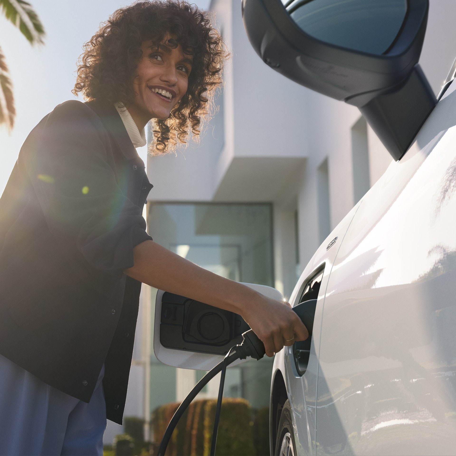 Vrouw sluit elektrakabel aan aan Q3  e-hybrid