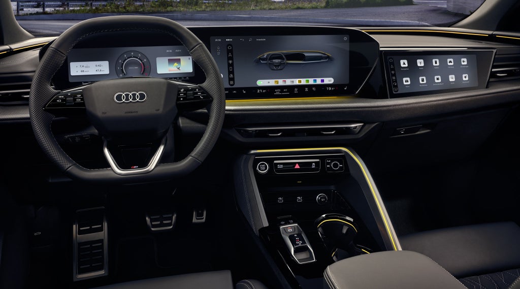 Blick in das Cockpit des Q5 Sportback aus Sicht des Fahrers. Zu sehen sind unter anderem das MMI touch-Display und das Audi virtual Cockpit hinter dem Lenkrad.