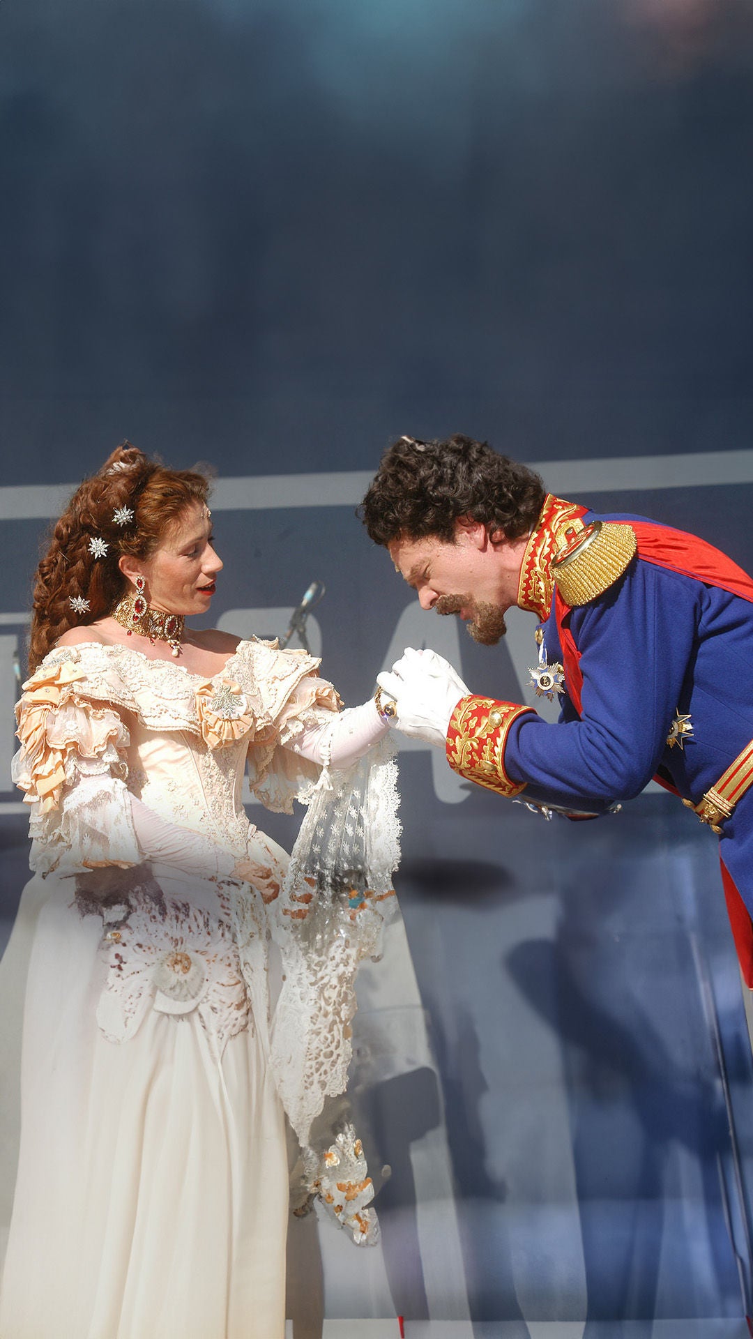 Zwei kostümierte Personen führen ein Stück auf der Bühne auf.