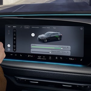 Nahaufnahme des MMI Displays im Cockpit des Q5 SUV e-hybrid. Auf dem Bildschirm sind die verschiedenen Fahrmodi des Fahrzeuges zu sehen.