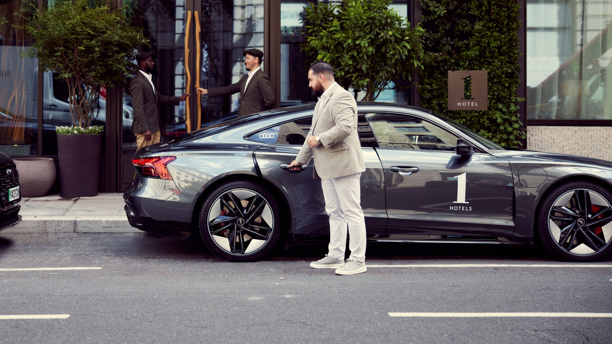 Person in formal attire opening back seat gate of Audi Rs e-tron GT