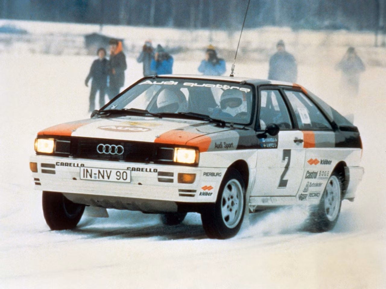 Audi quattro i ett race 1983, vinterunderlag med människor i snörök i bakgrunden. 