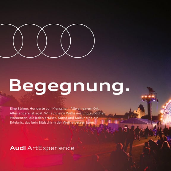 Großes Open-Air-Konzert bei Nacht mit beleuchteter Bühne und Publikum im Vordergrund, Schriftzug „Begegnung“.