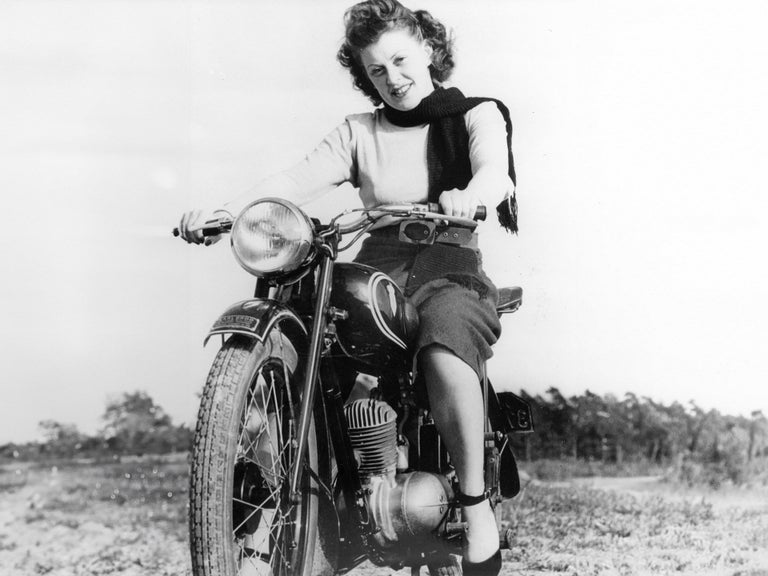 Frontal black and white photo of a woman on a DKW RT 125 W