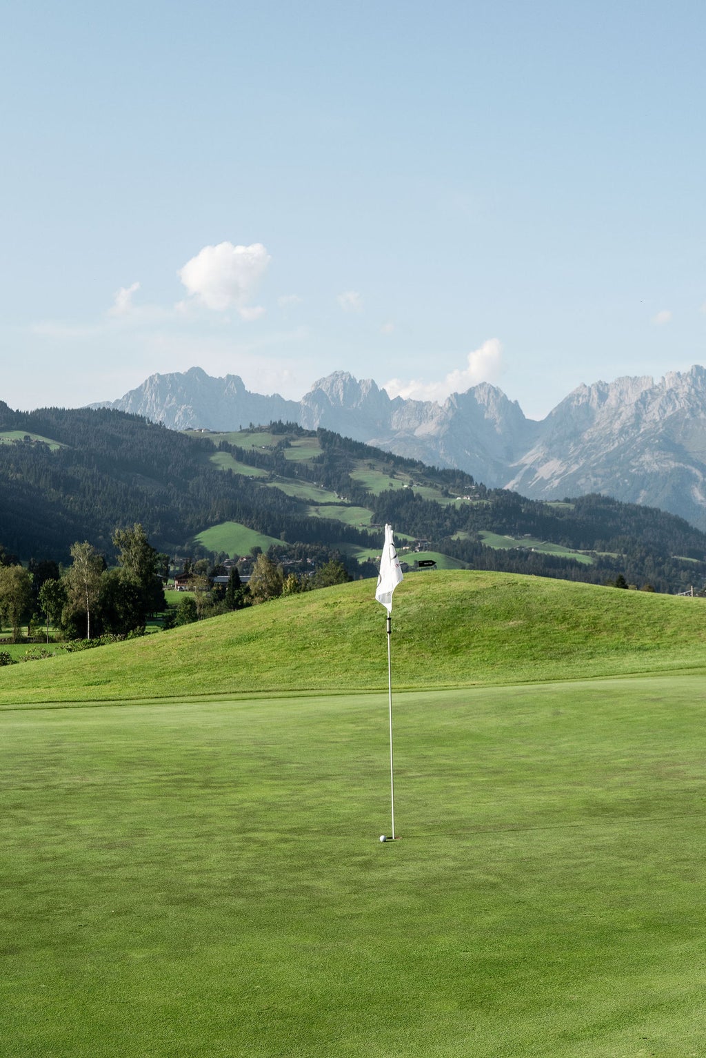 Vaste green vallonné, en arrière-plan les montagnes : le parcours de golf de Kitzbühel bénéficie d'un cadre magnifique.