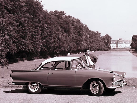 Eine Person sitzt in einem Auto Union 1000 SP Coupé, an dem eine andere Person lehnt