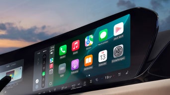 Nahaufnahme eines Touchscreens im Audi mit geöffneter Smartphone-Schnittstelle, Apps wie Telefon, Musik und Karten sichtbar.