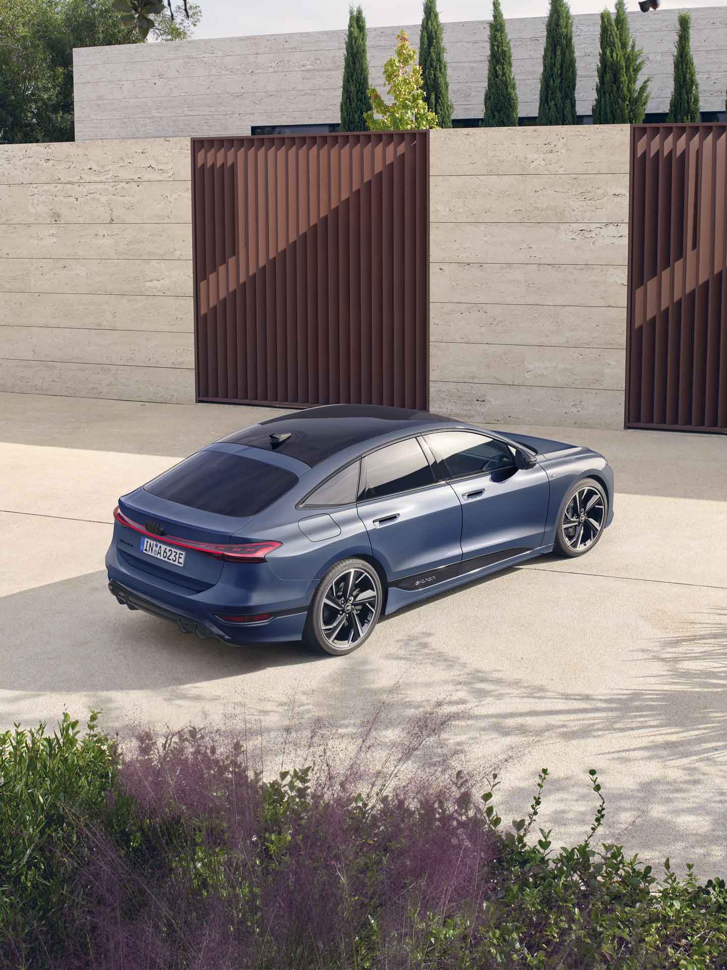 Blå A6 Sportback e-tron står parkerad vid en grind