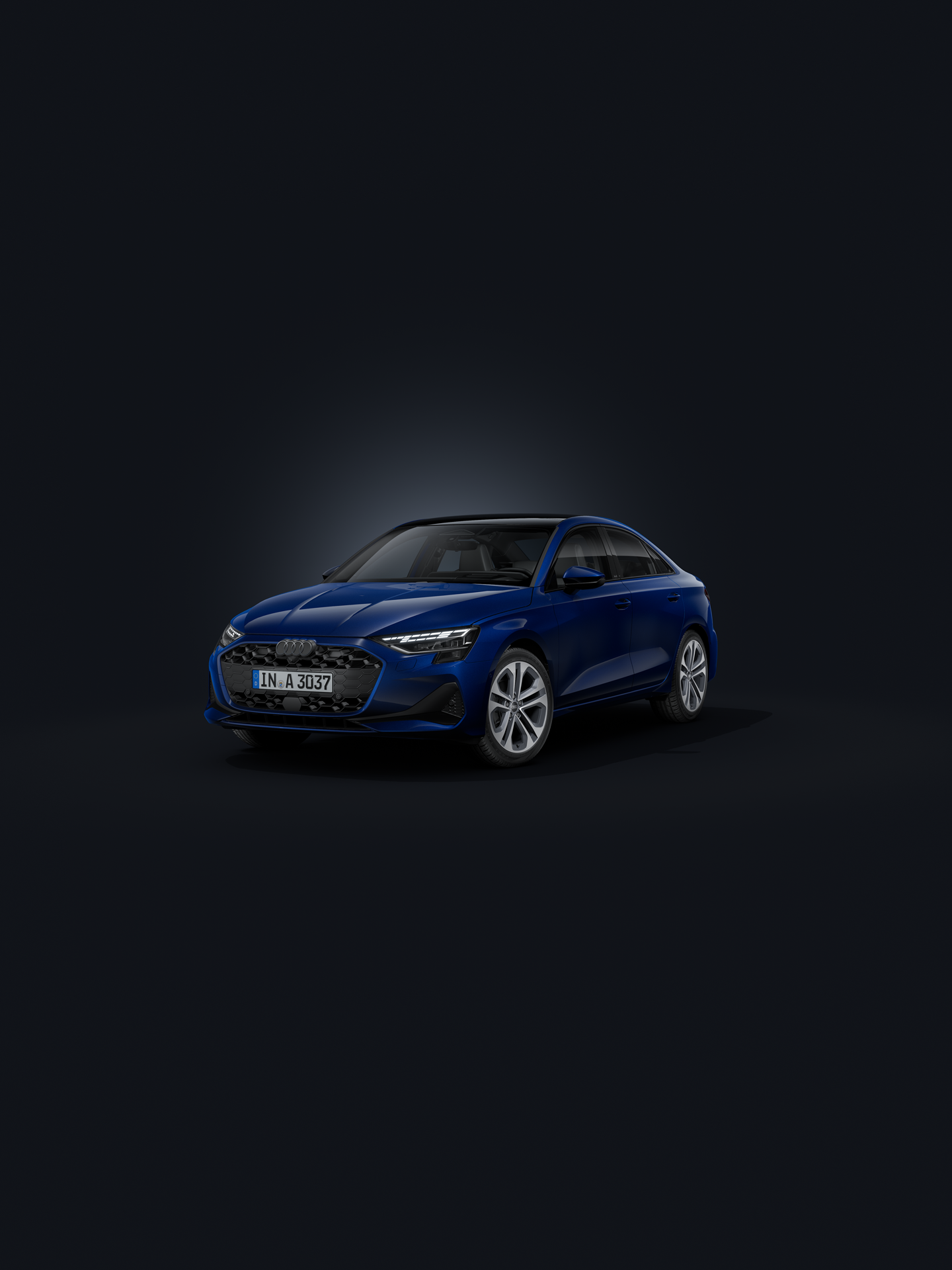 Die Audi A3 Limousine frontal von der Seite auf dunklem Hintergrund.