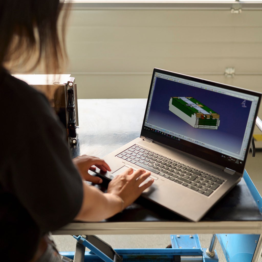 Aylin Reyhan schaut auf den Bildschirm ihres Desktops, worauf sie eine 3D-Ansicht einer Autobatterie hat
