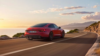 Red Audi e-tron GT quattro on the move in a coastal road