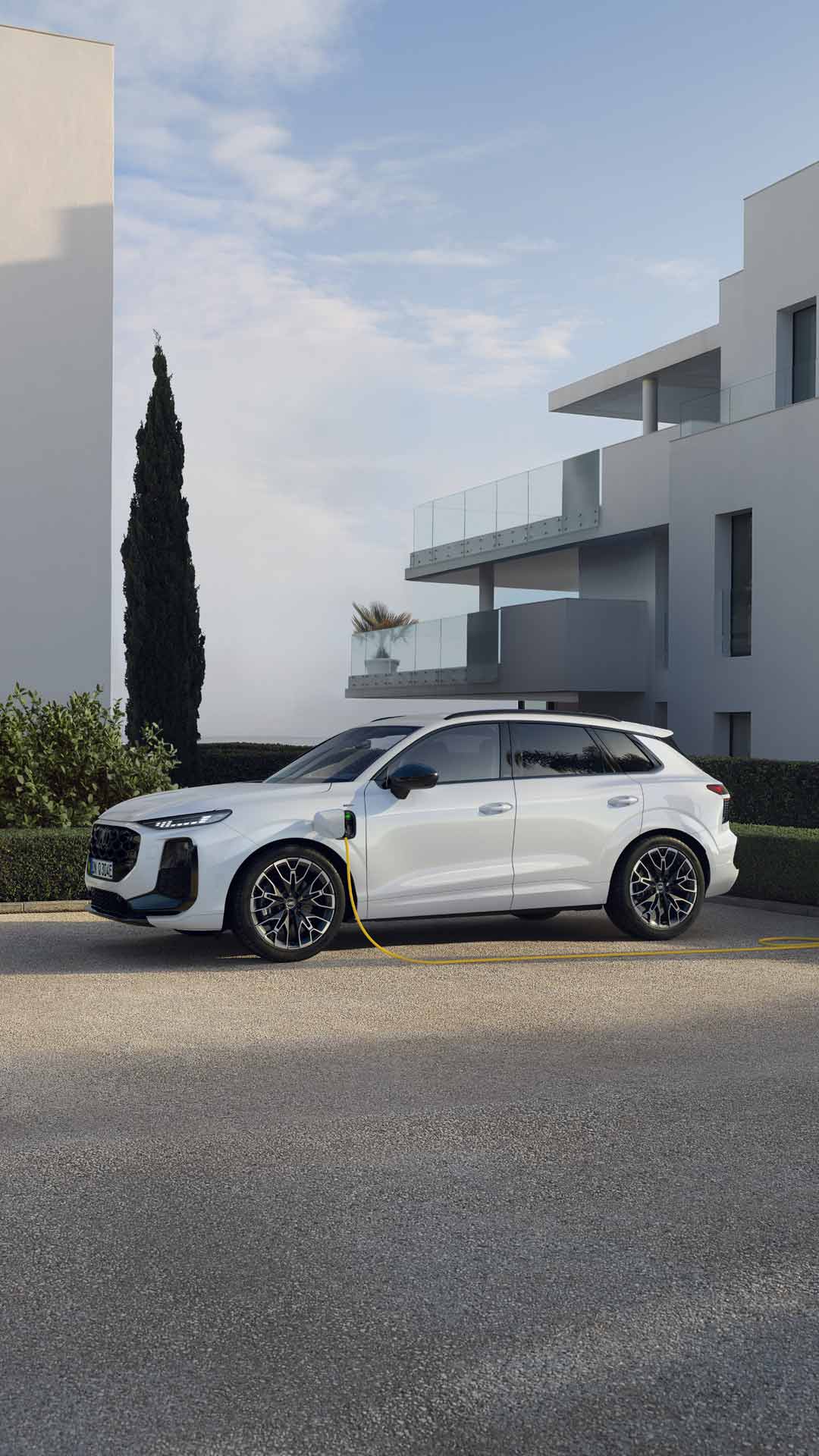 Vue latérale de l'Audi Q3 SUV e-hybrid en train de charger dans un parking