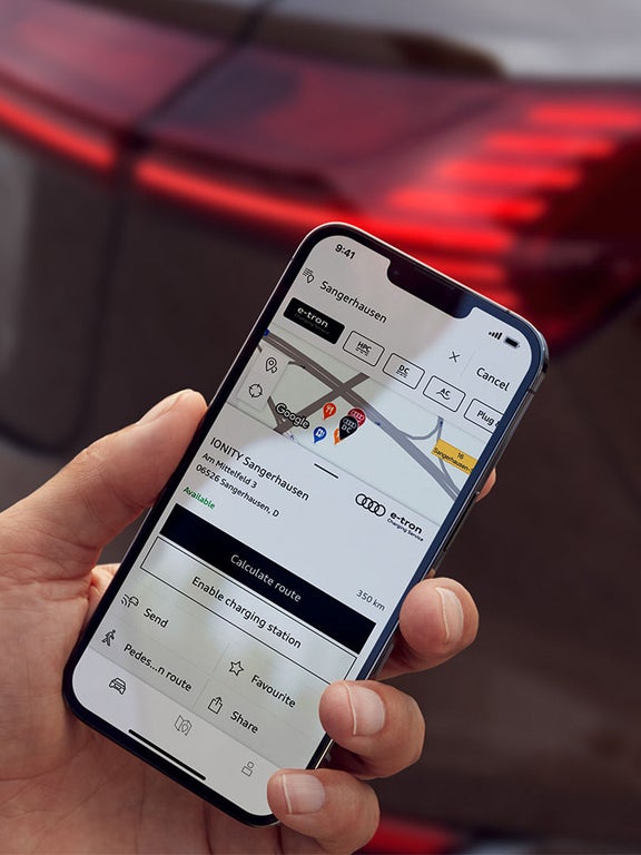 Man with smartphone in front of Audi Q8 Sportback e-tron