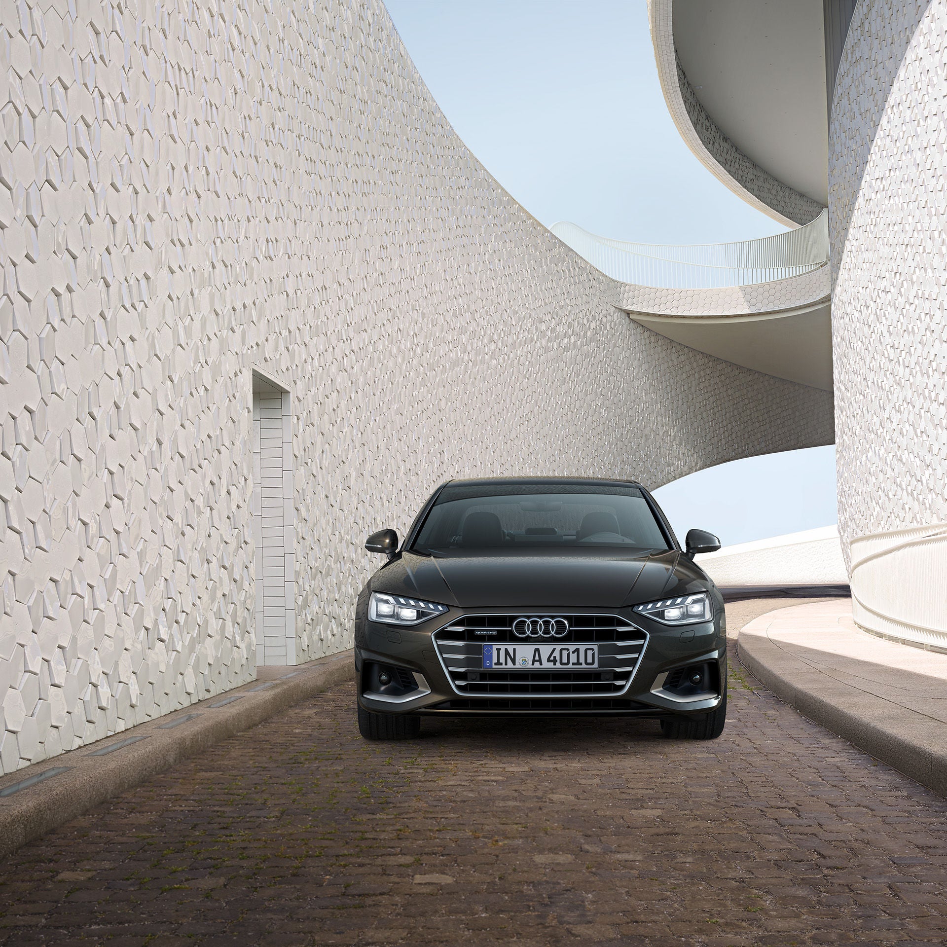 Framvy av en svart Audi A4 körande ned för en kullerstens backe