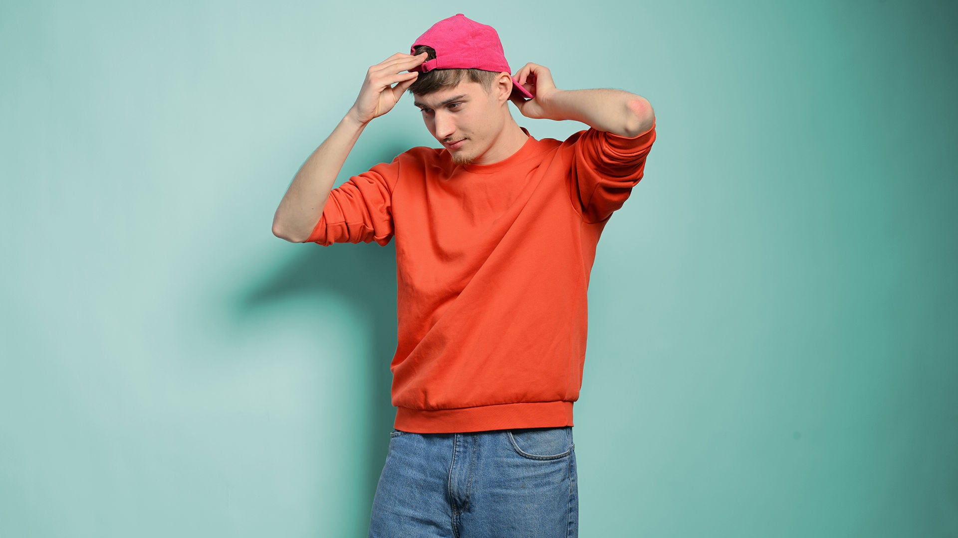 Noah schaut nach unten und richtet seine Cap, die er auf dem Kopf trägt