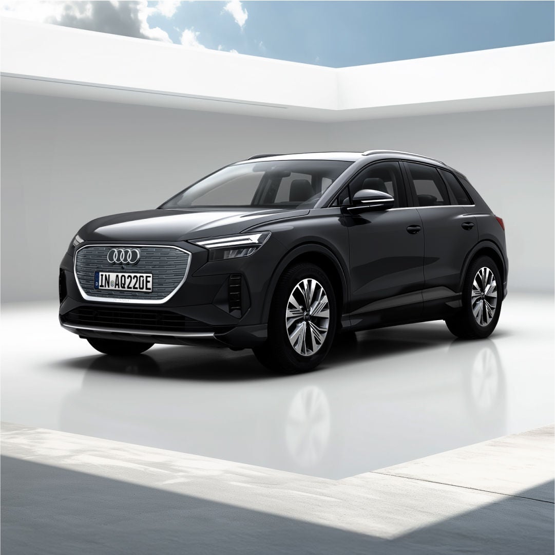 Schwarzer Audi Q4 e-tron steht auf einem hellen Untergrund unter einem offenen Dach, durch das ein blauer Himmel zu sehen ist