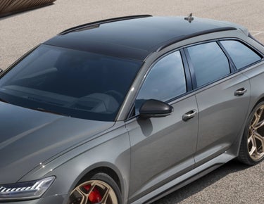 Side view of a grey car with tinted windows and alloy wheels.