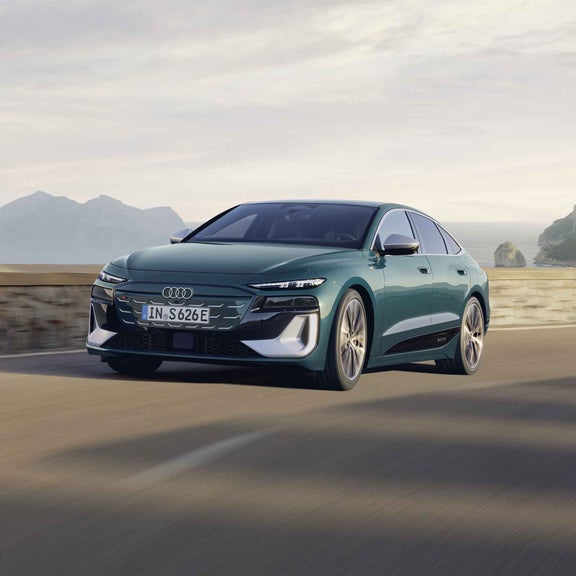 Der S6 Sportback e-tron im schrägen Frontprofil, während er eine Küstenstraße entlangfährt.