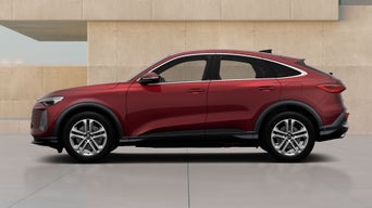A red Q5 Sportback e-hybrid parked against a textured beige backdrop, showcasing its modern design and sporty features from a side view.