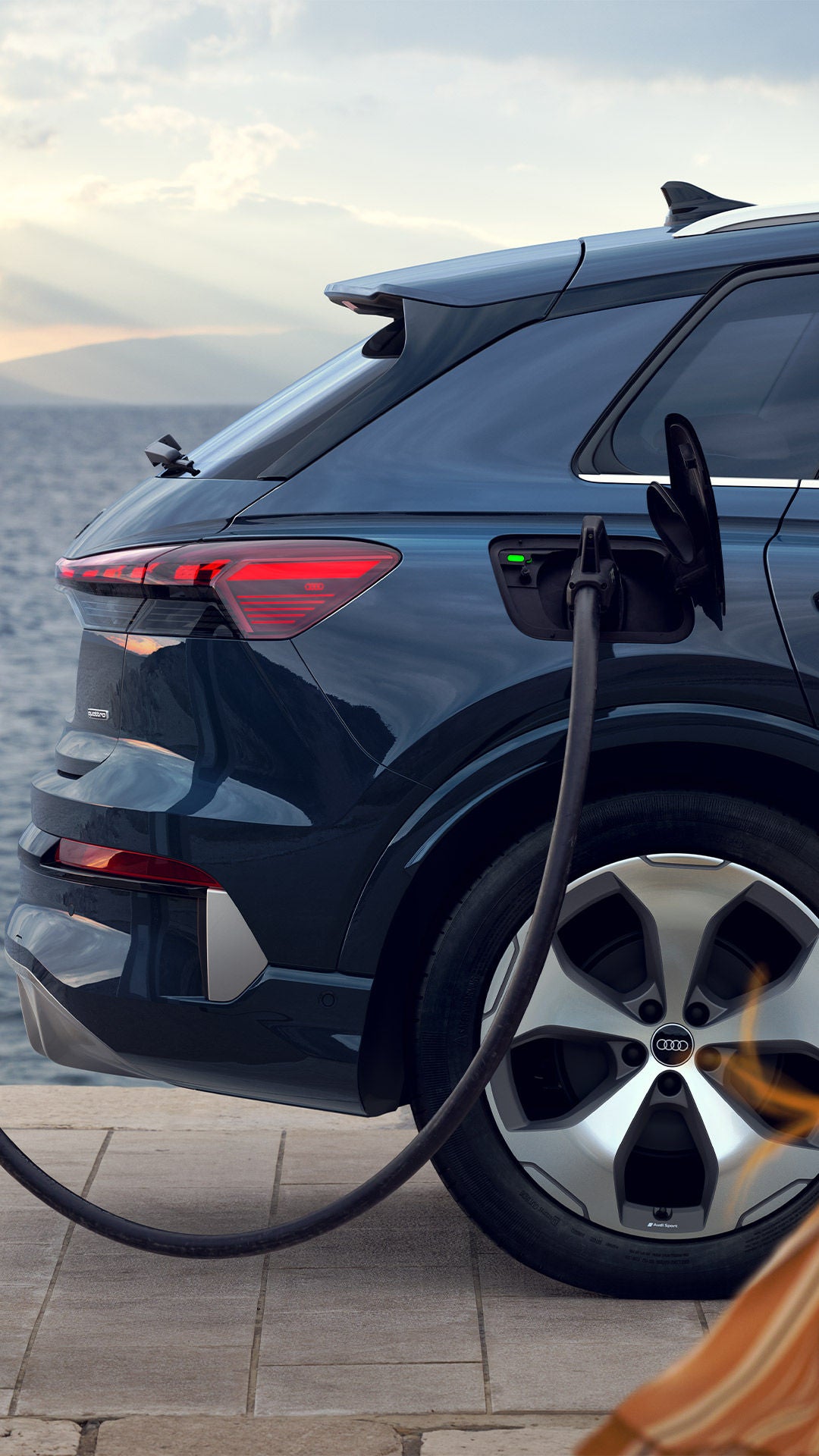 SUV électrique Audi en recharge au bord de l’eau.