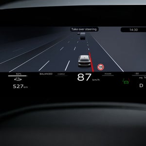 Close-up van een display in het interieur van het voertuig.  Het silhouet van een rechtdoor rijdend voertuig wordt weergegeven.  Daaronder worden onder meer de huidige snelheid en de resterende actieradius weergegeven.